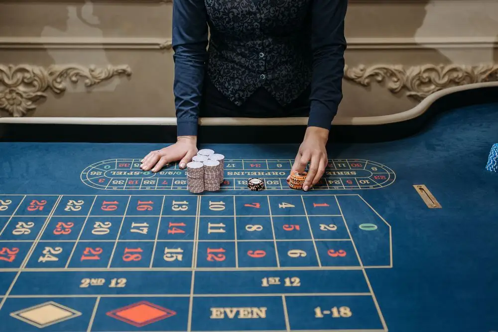 Casino dealer arranging chips on a felt table
